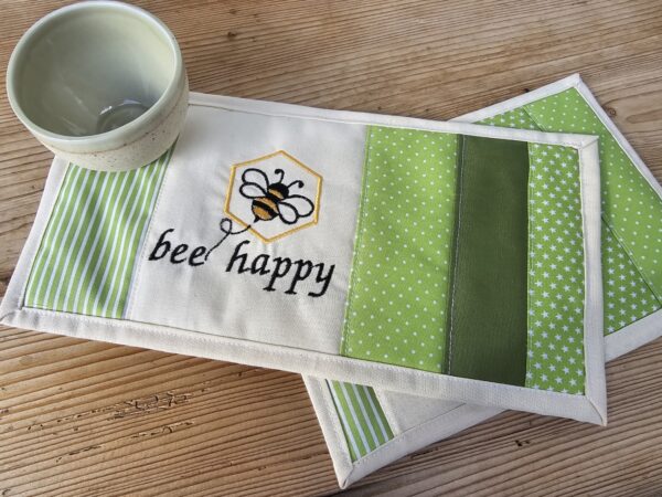 Tassenuntersetzer in Patchworkarbeit, bestickt mit einer Biene und "bee happy". 15 x 30 cm Größe, Mitbringsel und Geschenkidee für Honigliebhaber